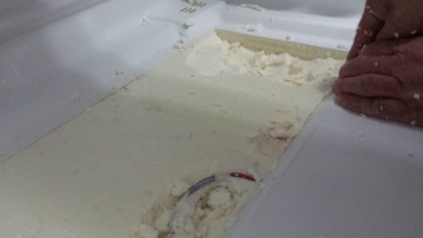 Slowly cutting through the wall and removing the foam one piece at a time.